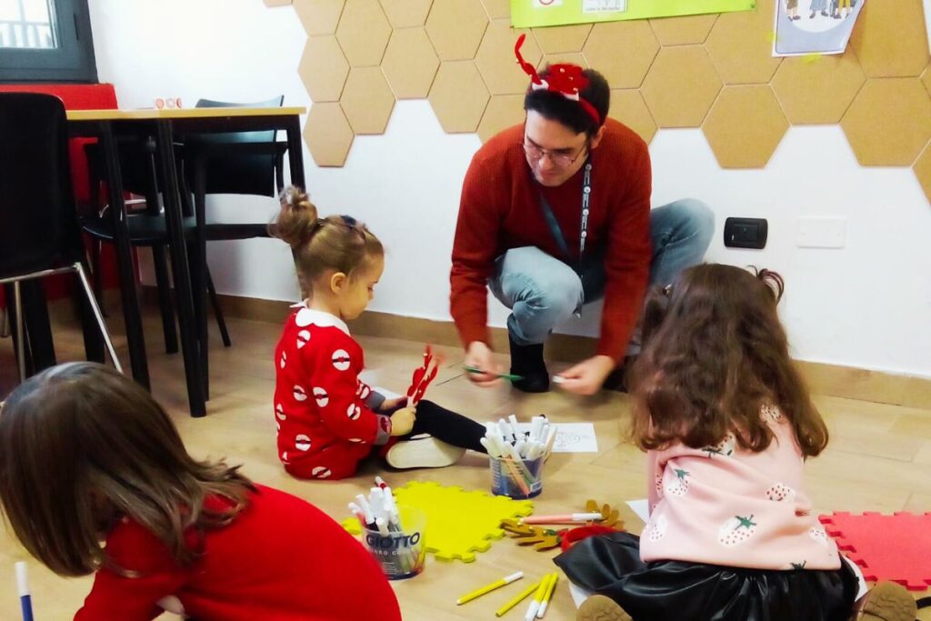 Bambini impegnati in attività creative natalizie in inglese durante il laboratorio Christmas Village di International House San Donato